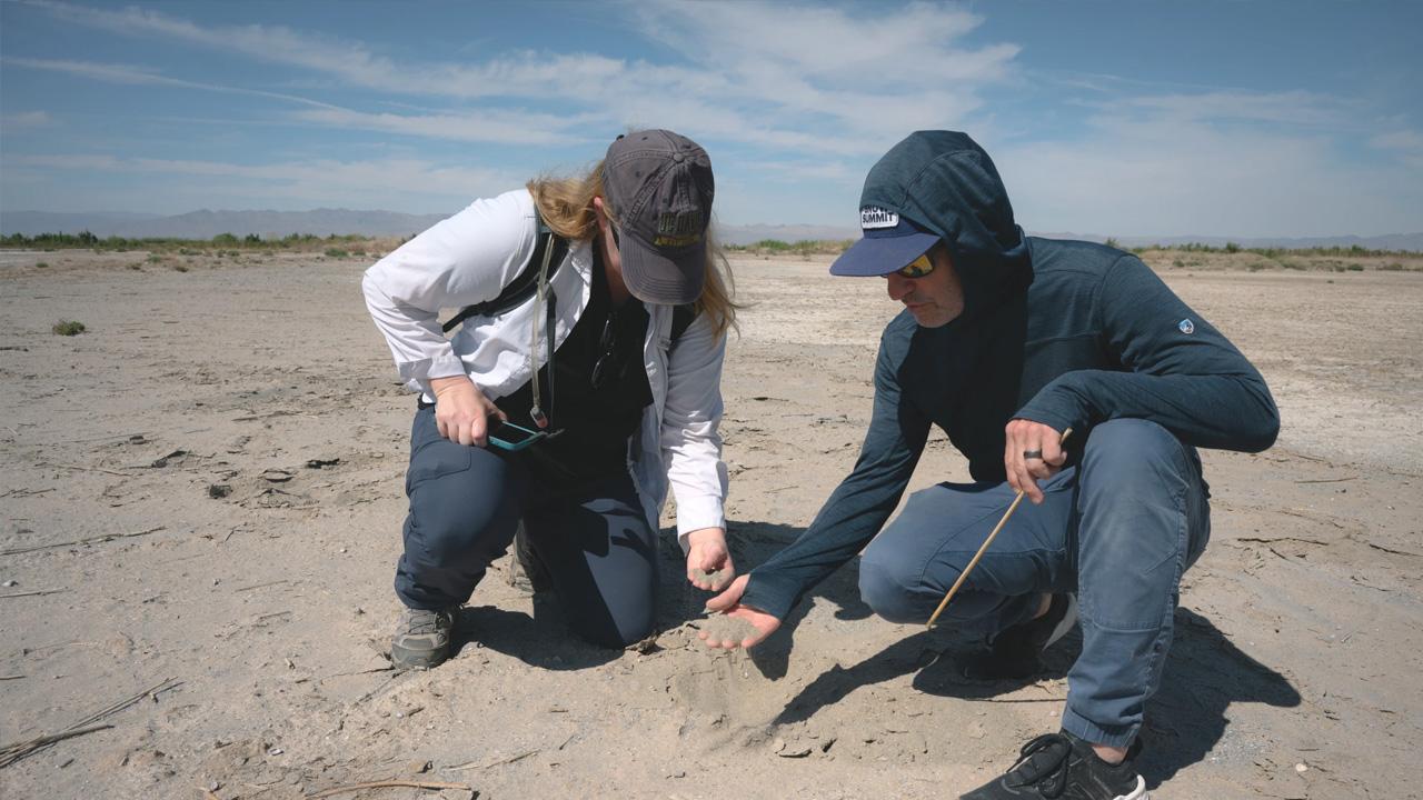 UC Dust professors Amato Evan and Rebecca Lybrand examine the soil along the edge of the Salton Sea at the mouth of the Alamo River near Calipatria, California on April 21, 2025. Their team is working on a new state-funded study into the types of materials embedded in the dust around the Salton Sea.